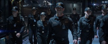 Movie still from “Captain America: The Winter Soldier” (2014), directed by Anthony Russo – A group of men in uniform walking in a line; Medium shot, Over the shoulder angle