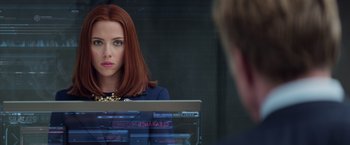 Movie still from “Captain America: The Winter Soldier” (2014), directed by Anthony Russo – A woman sitting in front of a computer looking into a mirror; Close Up shot, Over the shoulder angle