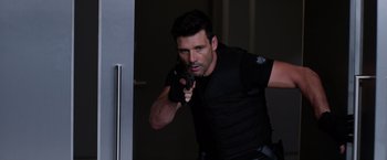 Movie still from “Captain America: The Winter Soldier” (2014), directed by Anthony Russo – A man holding a gun while standing in front of a mirror; Medium shot, Over the shoulder angle