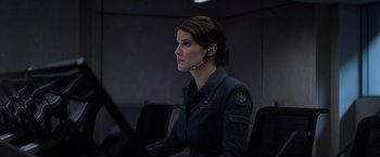 Movie still from “Captain America: The Winter Soldier” (2014), directed by Anthony Russo – A woman with a headset is sitting at a computer desk; Medium shot, Over the shoulder angle