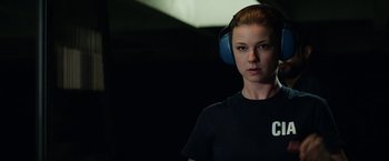 Movie still from “Captain America: The Winter Soldier” (2014), directed by Anthony Russo – A woman wearing ear muffs while standing in a room; Close Up shot, Over the shoulder angle