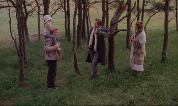 Movie still from “The Sacrifice” (1986), directed by Andrei Tarkovsky – A group of people standing in the grass near a tree; Wide shot, High angle