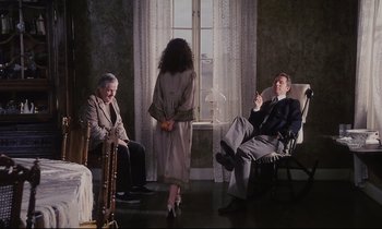 Movie still from “The Sacrifice” (1986), directed by Andrei Tarkovsky – A group of people sitting in a living room next to each other; Wide shot, High angle