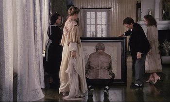 Movie still from “The Sacrifice” (1986), directed by Andrei Tarkovsky – A group of people standing next to a painting of an old man; Wide shot, High angle