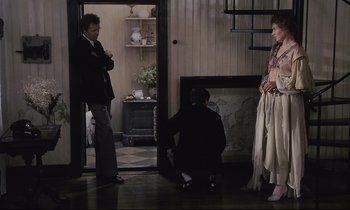Movie still from “The Sacrifice” (1986), directed by Andrei Tarkovsky – Two men and a woman are standing in a room; Wide shot, High angle