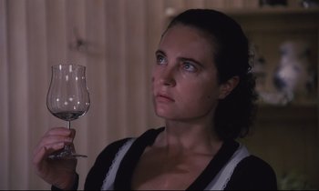 Movie still from “The Sacrifice” (1986), directed by Andrei Tarkovsky – A woman holding a wine glass in her right hand; Close Up shot, High angle