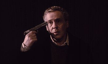 Movie still from “The Sacrifice” (1986), directed by Andrei Tarkovsky – A man holding a gun up to his head; Close Up shot, Low angle