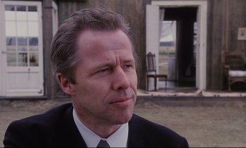 Movie still from “The Sacrifice” (1986), directed by Andrei Tarkovsky – A person wearing a suit and tie; Close Up shot, Low angle