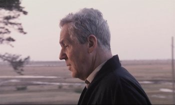 Movie still from “The Sacrifice” (1986), directed by Andrei Tarkovsky – An older man is looking off into the distance; Close Up shot, Over the shoulder angle