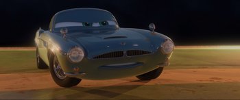 Movie still from “Cars 2” (2011), directed by John Lasseter – The front end of a cartoon car; Wide shot, Low angle