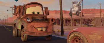 Movie still from “Cars 2” (2011), directed by John Lasseter – A cartoon character's face in the background; Wide shot, Low angle
