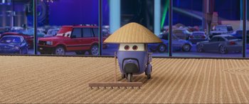 Movie still from “Cars 2” (2011), directed by John Lasseter – A toy car with an asian hat on top of it; Wide shot, High angle