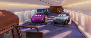 Movie still from “Cars 2” (2011), directed by John Lasseter – A purple car and a silver car are in a plane; Wide shot, Low angle