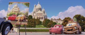Movie still from “Cars 2” (2011), directed by John Lasseter – A painting of a pink car in front of a painting of a church; Wide shot, Low angle