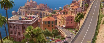 Movie still from “Cars 2” (2011), directed by John Lasseter – An aerial view of a city with cars parked on the side of the road; Extreme Wide shot, High angle