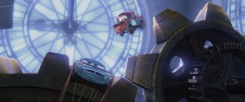 Movie still from “Cars 2” (2011), directed by John Lasseter – A scene from cars movie with mater and lightning mcqueen in the background; Wide shot, Low angle