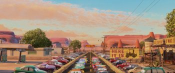 Movie still from “Cars 2” (2011), directed by John Lasseter – A street filled with lots of cars on it's sides; Extreme Wide shot, High angle