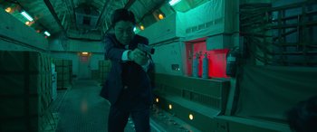 A man in a suit and tie holding a gun