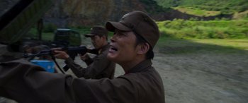 Movie still from “Carter” (2022), directed by Jung Byung-gil – Two men in brown uniforms are holding guns; Close Up shot, Over the shoulder angle