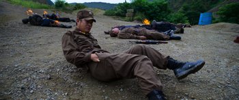 Movie still from “Carter” (2022), directed by Jung Byung-gil – A group of people laying on the ground; Medium shot, High angle