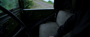 Movie still from “Carter” (2022), directed by Jung Byung-gil – A man sitting in a car with a rifle in his hand; Close Up shot, Over the shoulder angle