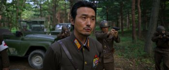 A man in a military uniform is holding a gun