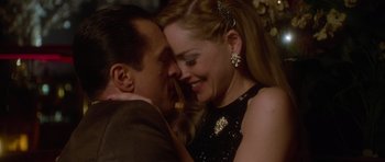 Movie still from “Casino” (1995), directed by Martin Scorsese – A man and a woman are hugging and smiling for the camera; Close Up shot, High angle