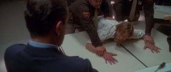 Movie still from “Casino” (1995), directed by Martin Scorsese – A police officer helping an injured person on the ground; Medium shot, Over the shoulder angle