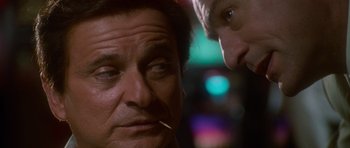Movie still from “Casino” (1995), directed by Martin Scorsese – A man with a cigarette in his mouth next to another man; Close Up shot, Low angle
