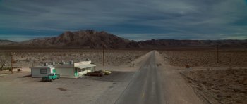 An empty road in the middle of the desert at night