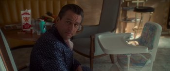 Movie still from “Casino” (1995), directed by Martin Scorsese – A man sitting on the floor next to a chair; Medium shot, High angle