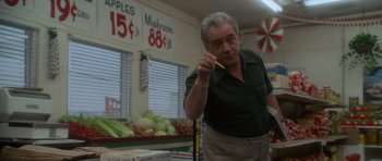 Movie still from “Casino” (1995), directed by Martin Scorsese – An older man is holding a knife in a store; Medium shot, Low angle