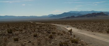 Movie still from “Casino” (1995), directed by Martin Scorsese – A car driving down a dirt road in the middle of the desert; Extreme Wide shot, High angle
