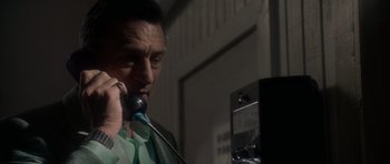 Movie still from “Casino” (1995), directed by Martin Scorsese – A man talking on a phone while wearing a green shirt; Close Up shot, Low angle