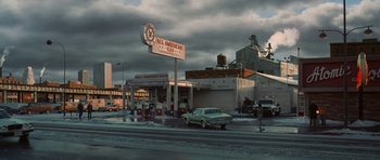 Movie still from “Casino” (1995), directed by Martin Scorsese – A car parked on the side of the road next to a gas station; Extreme Wide shot, High angle