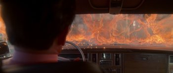 Movie still from “Casino” (1995), directed by Martin Scorsese – A man driving a car in front of a burning sky; Medium shot, Over the shoulder angle