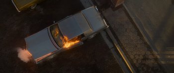 Movie still from “Casino” (1995), directed by Martin Scorsese – An aerial view of a car on fire on the side of the road; Extreme Wide shot, Overhead angle