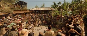 Movie still from “Casino Royale” (2006), directed by Martin Campbell – A group of people gathered in a circle on a beach; Extreme Wide shot, High angle