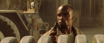 Movie still from “Casino Royale” (2006), directed by Martin Campbell – A person holding a gun in a room; Close Up shot, Low angle