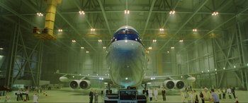 Movie still from “Casino Royale” (2006), directed by Martin Campbell – A large airplane in a hangar with people standing around it; Extreme Wide shot, Low angle
