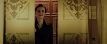 Movie still from “Casino Royale” (2006), directed by Martin Campbell – A woman in a black jacket standing in front of a door; Medium shot, Low angle