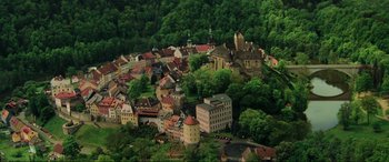 Movie still from “Casino Royale” (2006), directed by Martin Campbell – An aerial view of a town with many buildings and trees around it; Extreme Wide shot, High angle