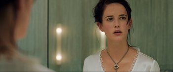 Movie still from “Casino Royale” (2006), directed by Martin Campbell – A young woman wearing a white shirt and a silver necklace; Close Up shot, Over the shoulder angle
