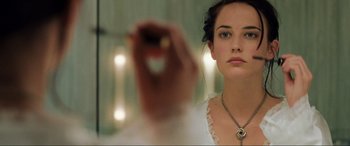 Movie still from “Casino Royale” (2006), directed by Martin Campbell – A woman is looking into a mirror while holding a cell phone; Close Up shot, Over the shoulder angle