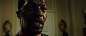 Movie still from “Casino Royale” (2006), directed by Martin Campbell – A man's face in a dark room; Close Up shot, Low angle