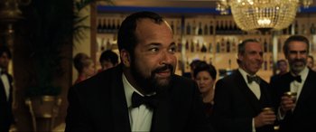 Movie still from “Casino Royale” (2006), directed by Martin Campbell – A man wearing a tuxedo and a bow tie in front of a bar; Close Up shot, Over the shoulder angle
