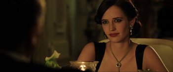 Movie still from “Casino Royale” (2006), directed by Martin Campbell – A woman sitting at a table with a candle in front of her; Close Up shot, Over the shoulder angle