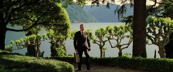 Movie still from “Casino Royale” (2006), directed by Martin Campbell – A man holding a briefcase standing in front of a lake; Wide shot, Over the shoulder angle