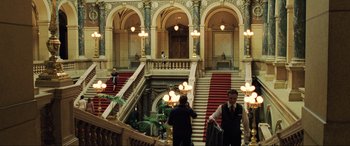 Movie still from “Casino Royale” (2006), directed by Martin Campbell – Two men walking up a set of stairs in a building; Extreme Wide shot, High angle