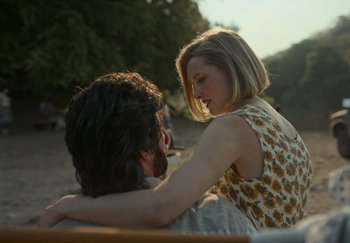 A man and a woman sitting on top of a bench